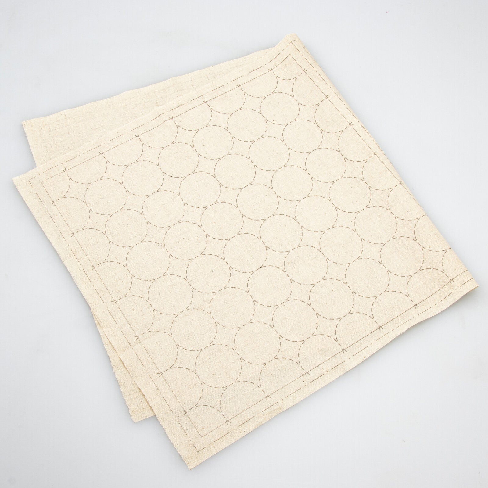 a natural cotton linen cloth printed with circles in a sashiko design