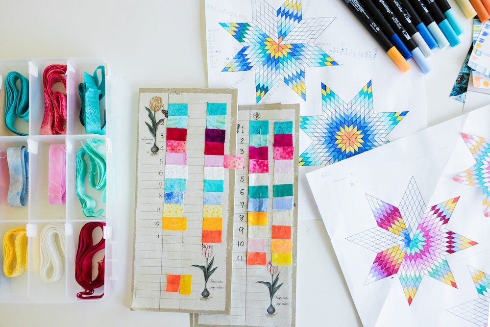 Colorful star patterns and art supplies on a white surface