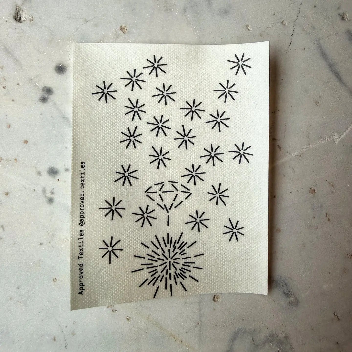 Textile with black star patterns on a textured surface