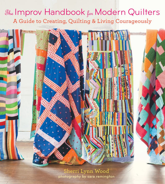 Book cover of 'The Improv Handbook for Modern Quilters' with colorful quilts on a wooden floor.