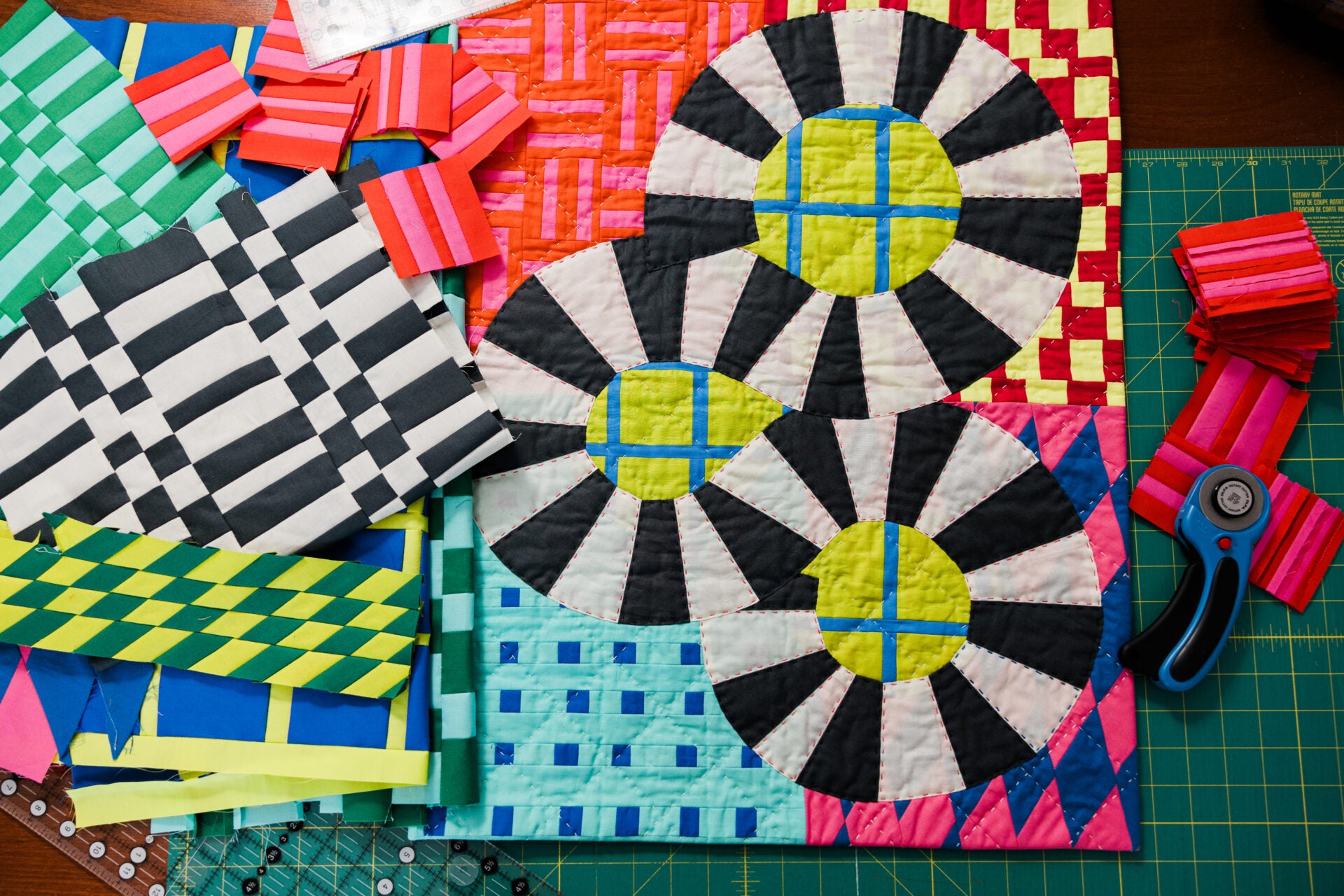 Colorful quilt with geometric patterns on a cutting mat with scissors