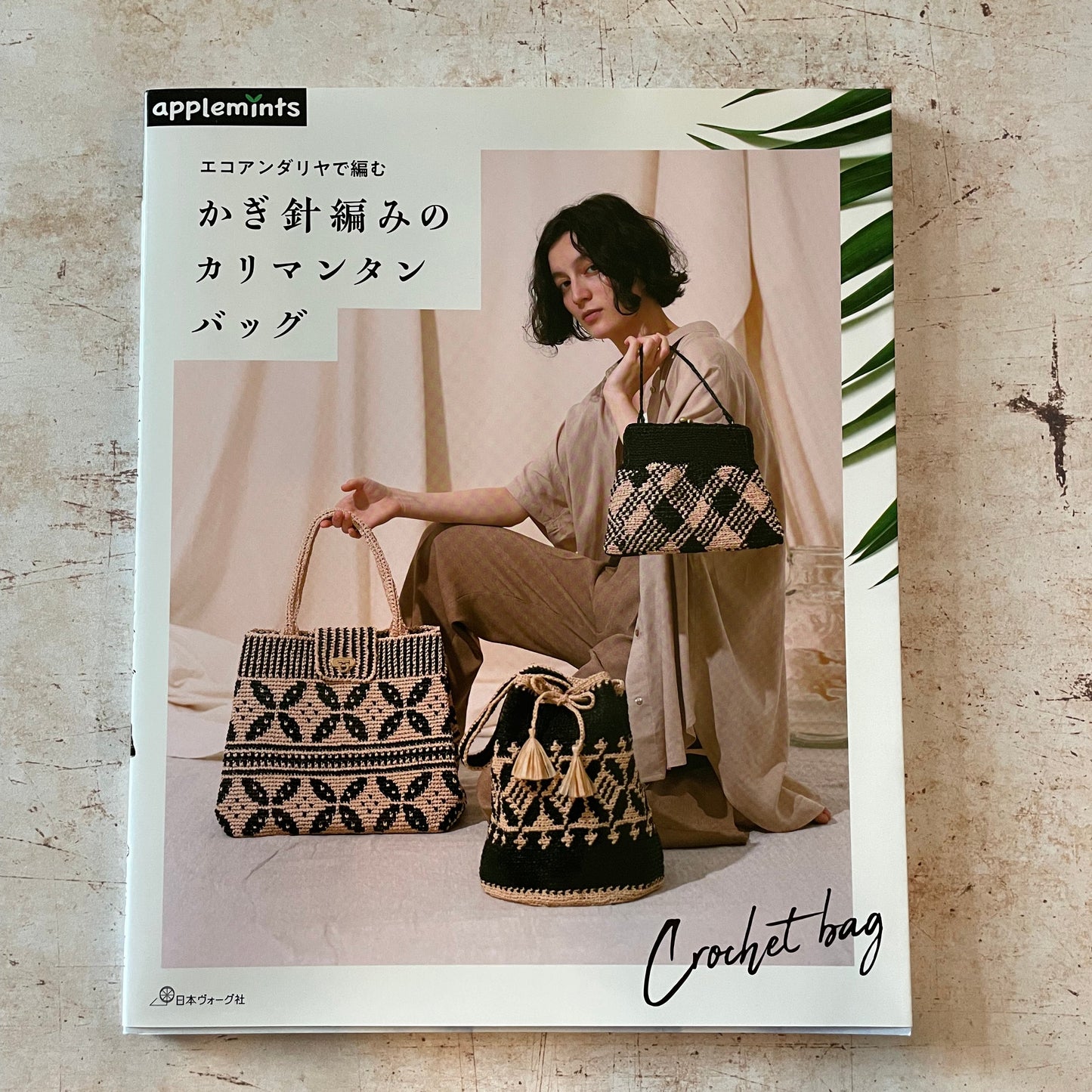 A woman with 3 black and tan crocheted bags