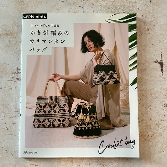 A woman with 3 black and tan crocheted bags