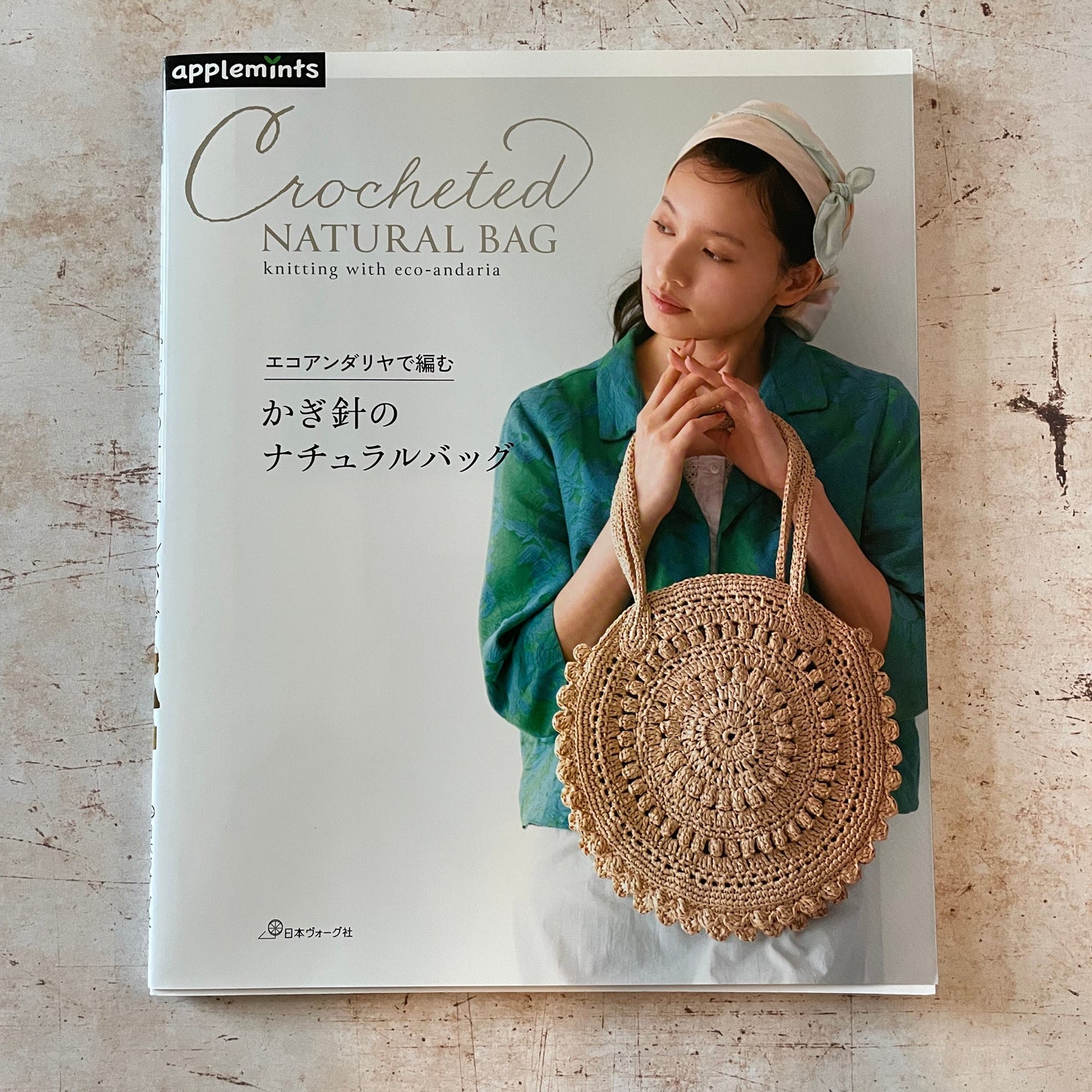 a woman holding a circular crocheted bag