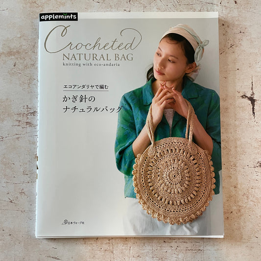 a woman holding a circular crocheted bag