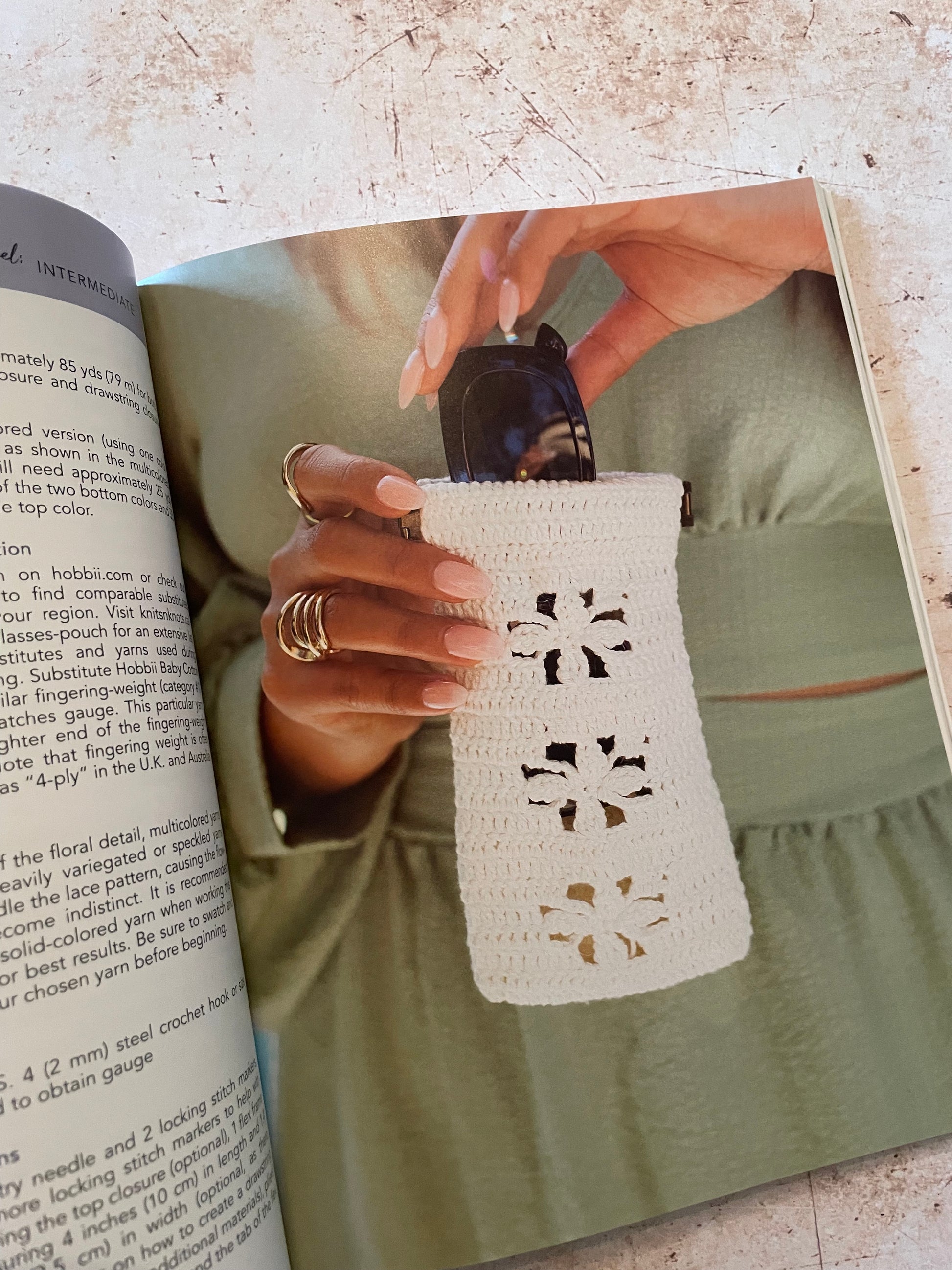Person holding a white lace crochet sunglass case