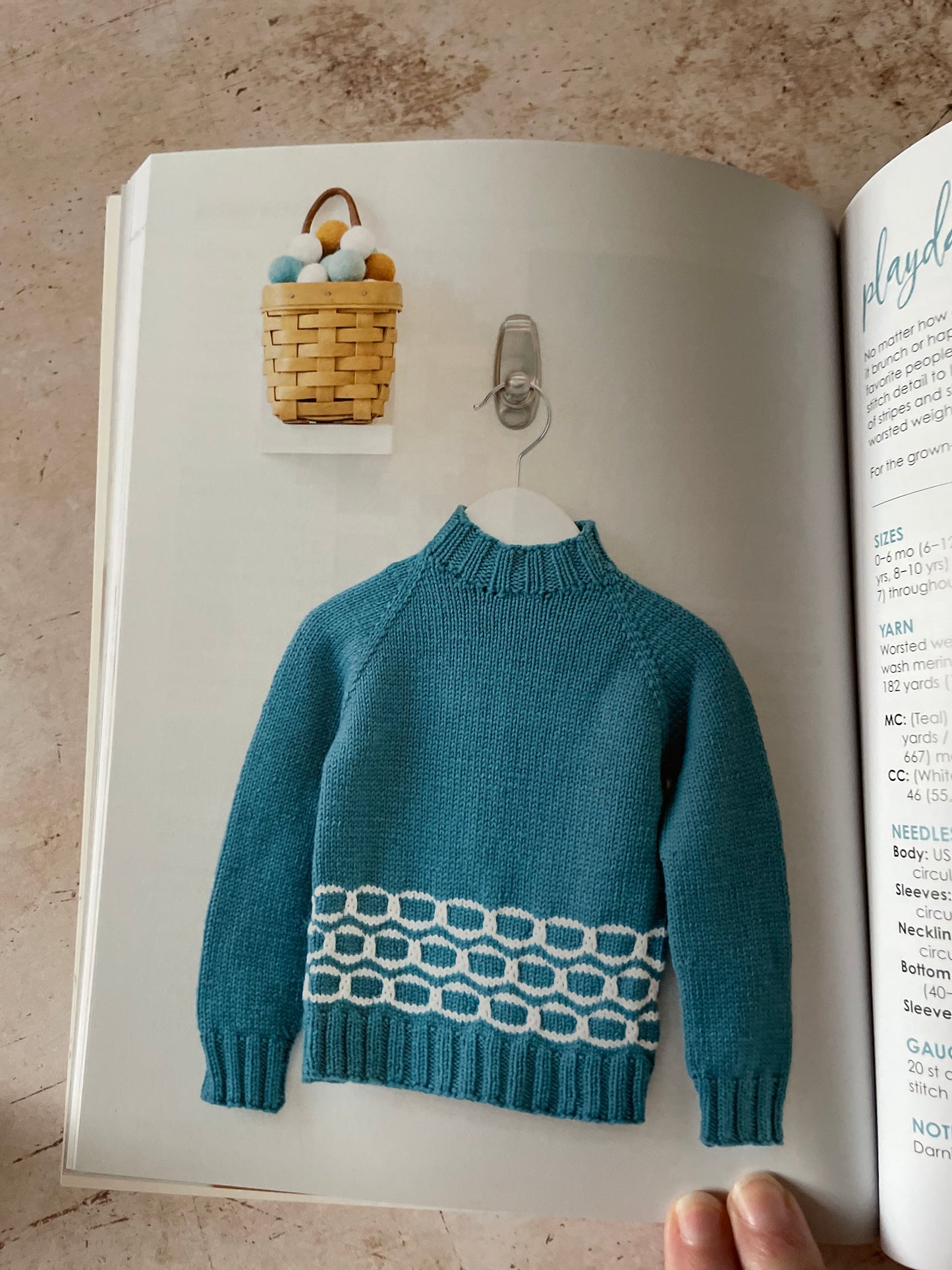 Blue knitted sweater with a white oval pattern on the hem