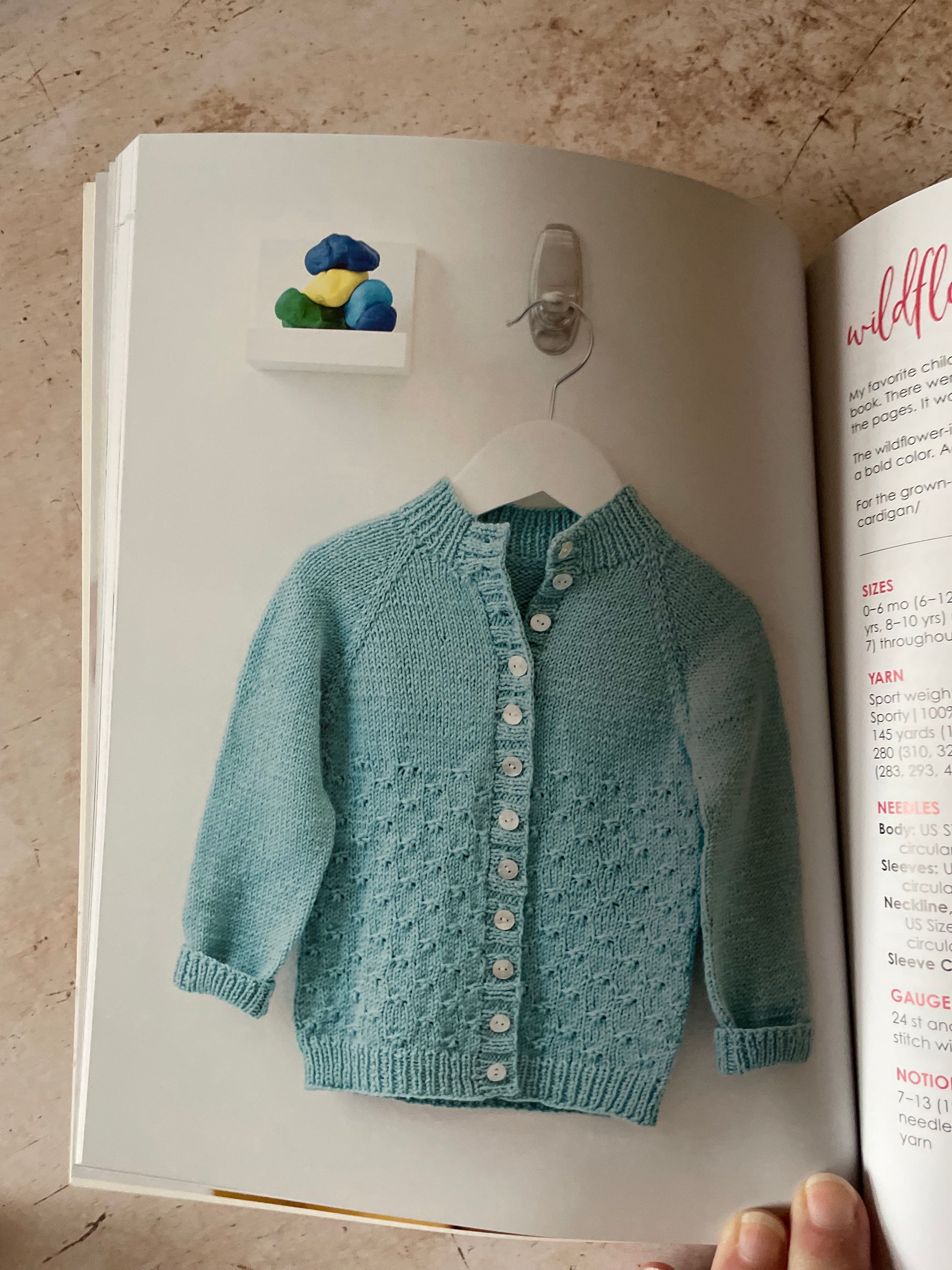 Blue knitted cardigan with a textured pattern and white buttons