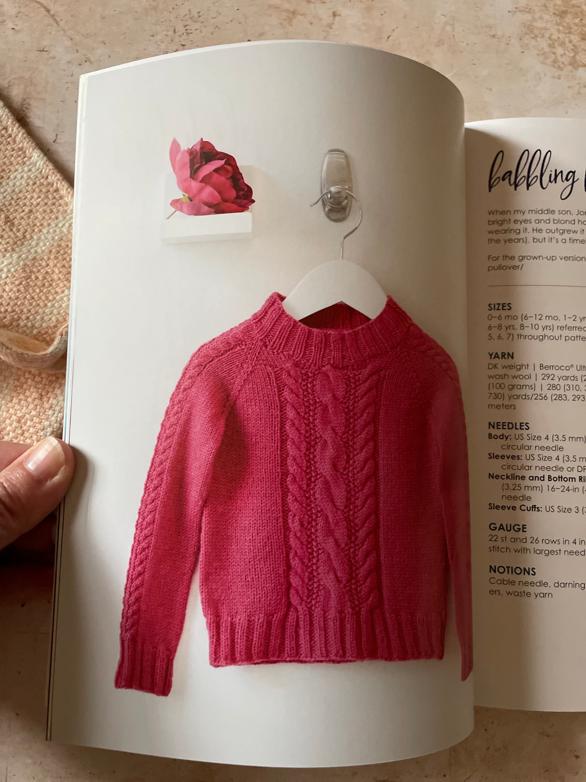 Red sweater displayed on a mannequin inside an open book