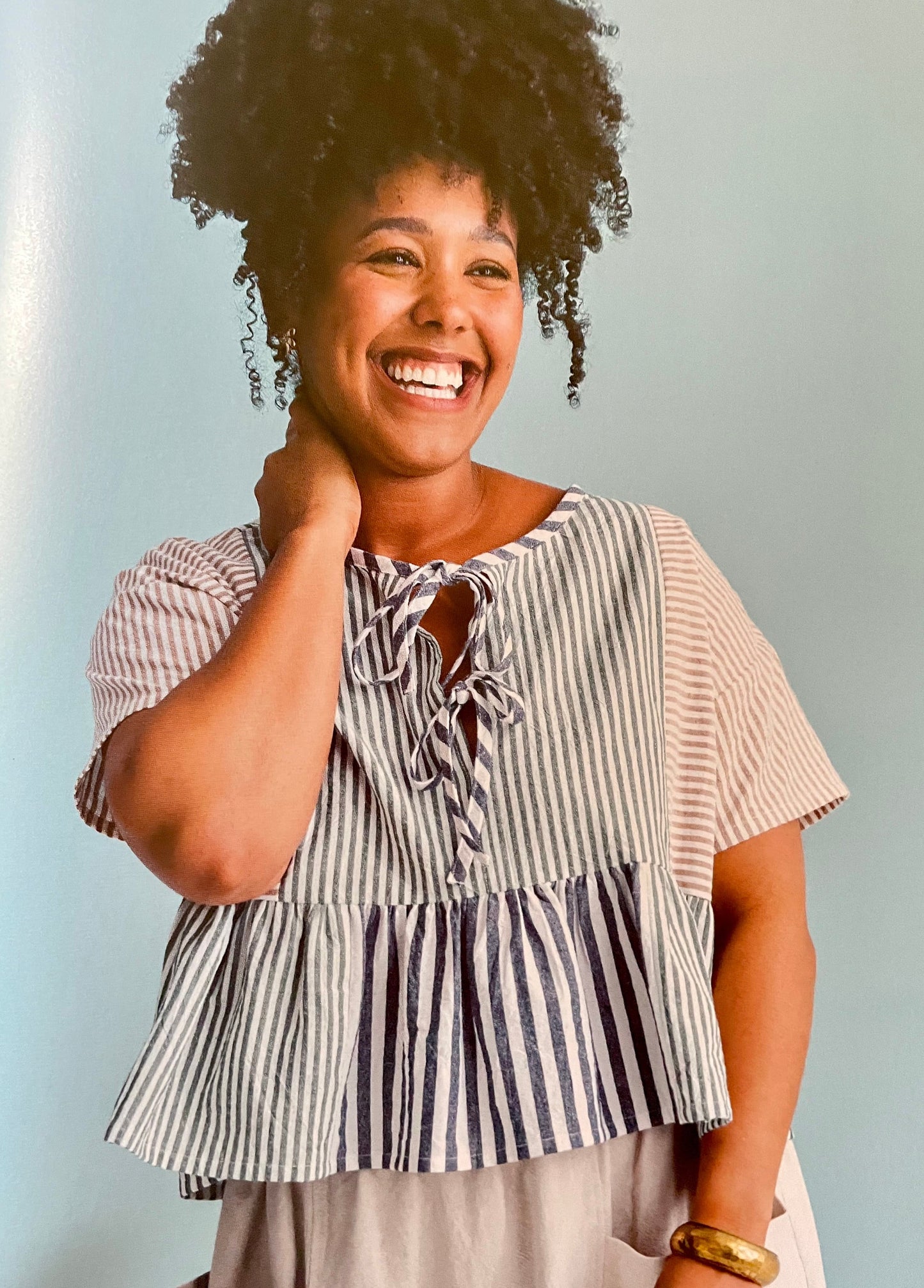 Woman wearing a striped top with a plain background