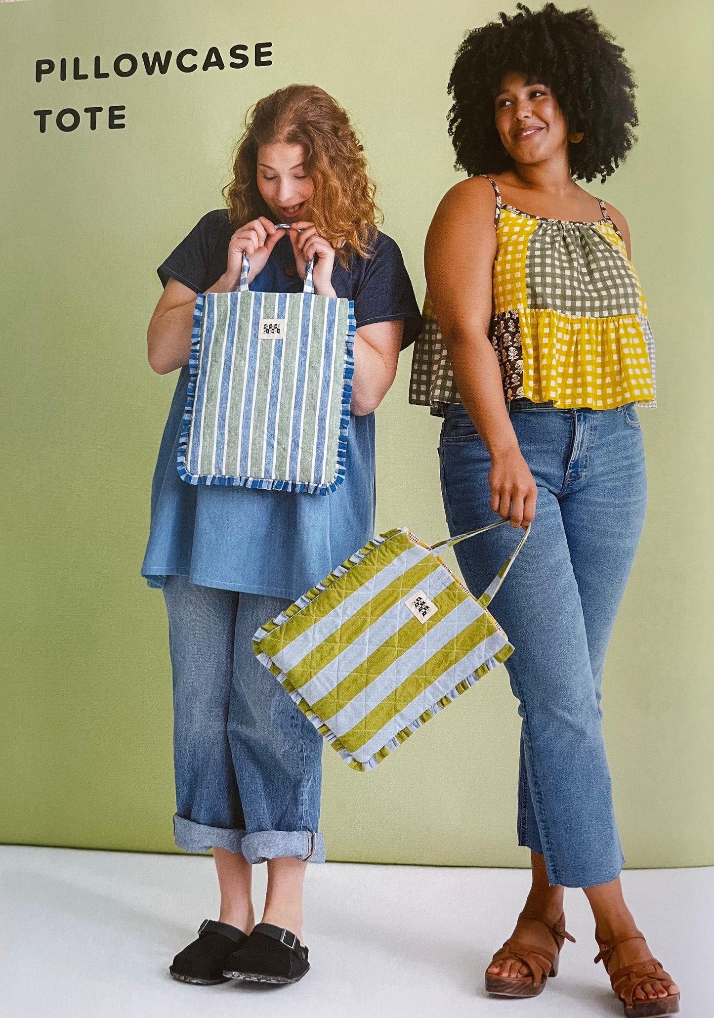 Two women holding striped tote bags against a green background
