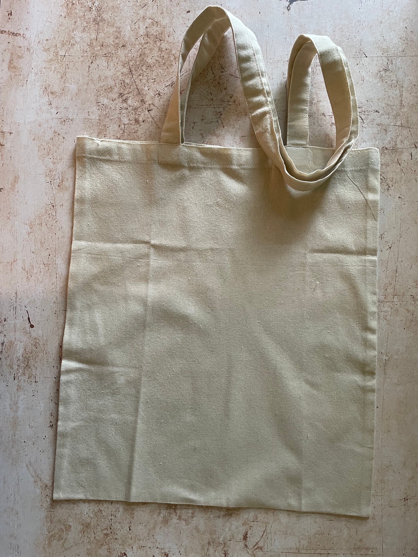 Beige tote bag on a textured surface