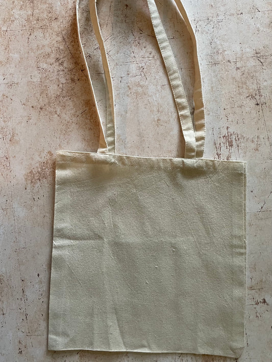 Beige tote bag on a textured beige surface