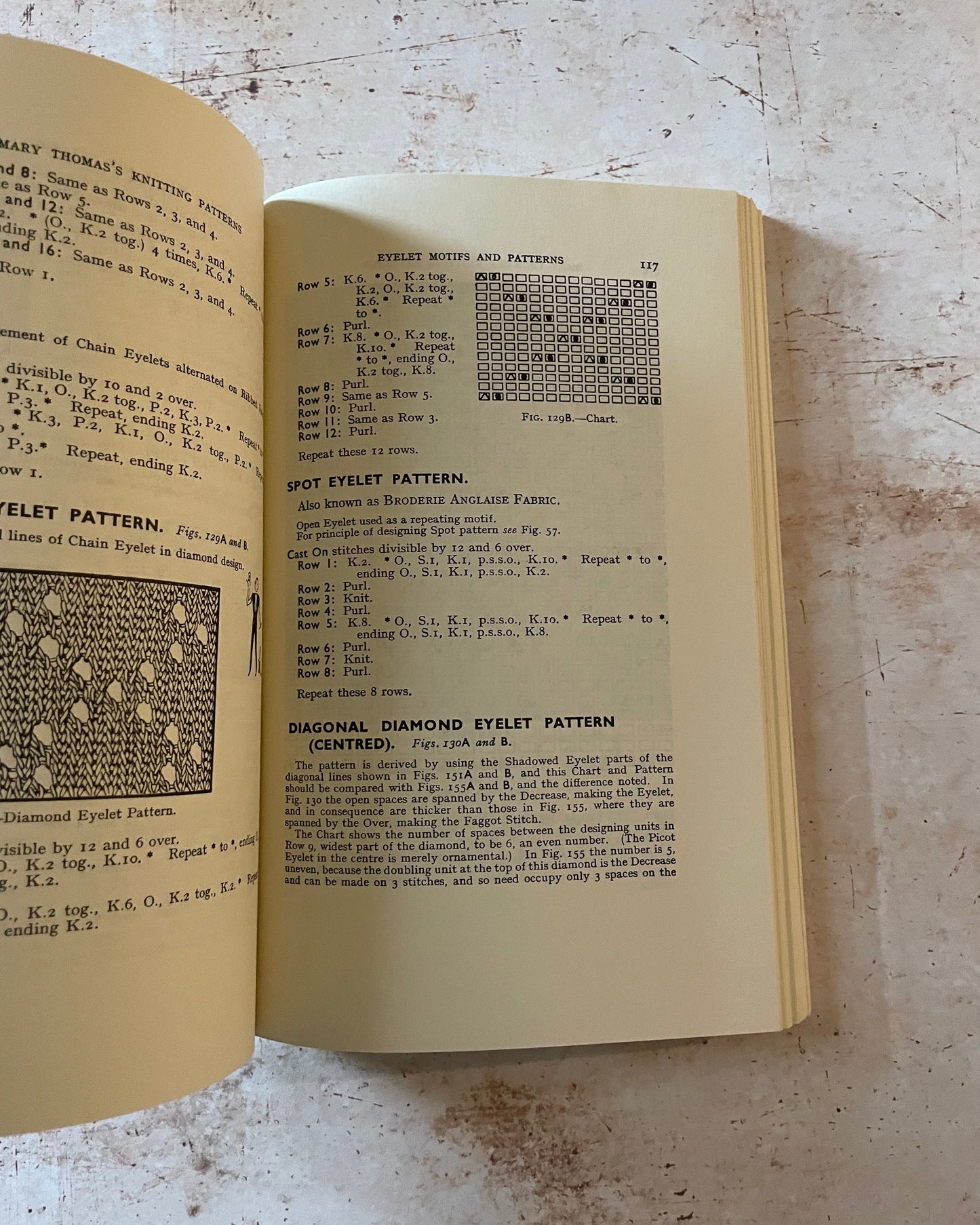 Open book with text and patterns on a textured surface