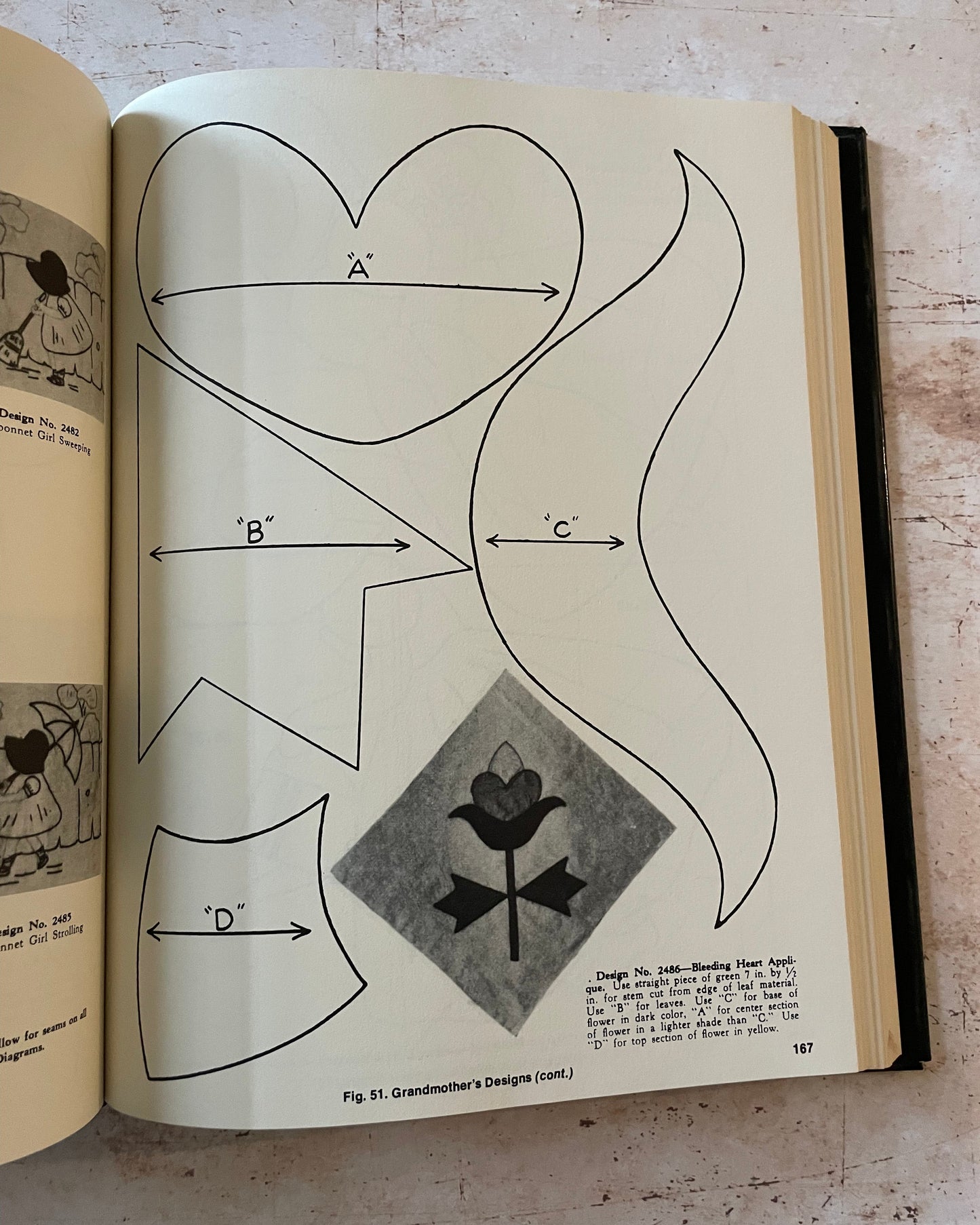 Open book showing a quilting design diagram with geometric shapes and text on a wooden surface.