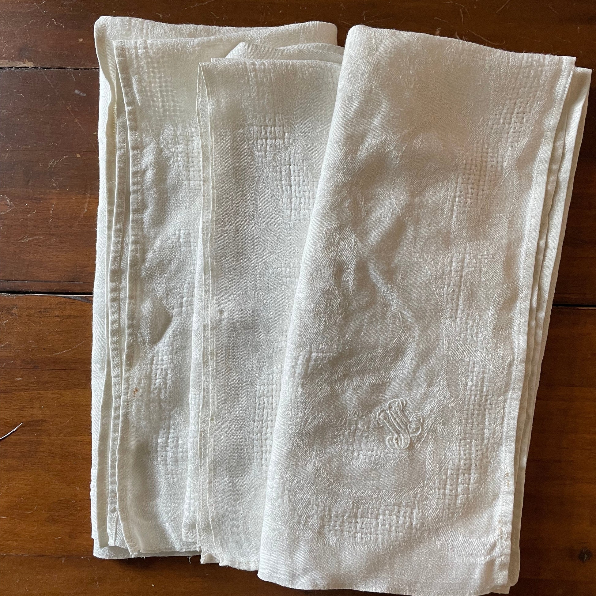Folded white cloth napkins on a wooden surface
