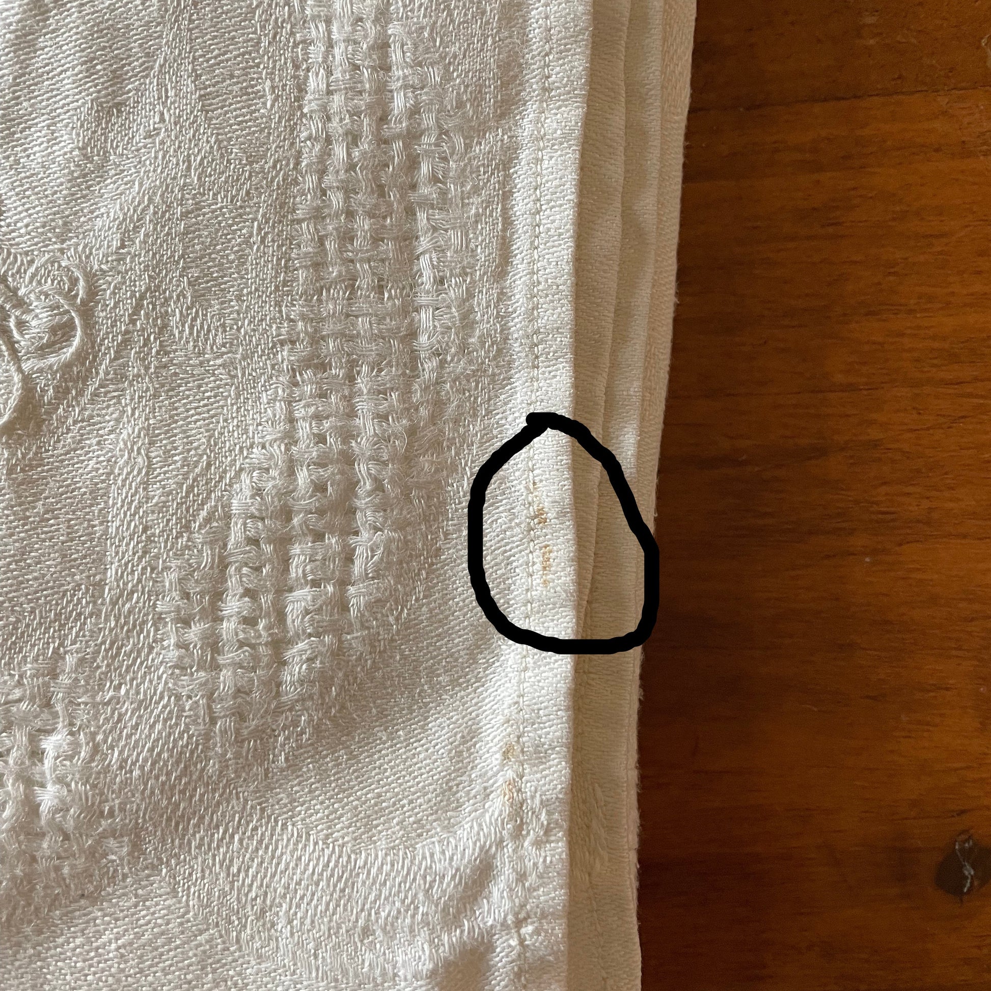 Close-up of a textured white fabric with a wooden surface in the background