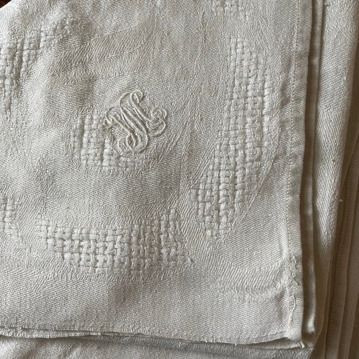 Close-up of a textured fabric with an embroidered design on a wooden surface