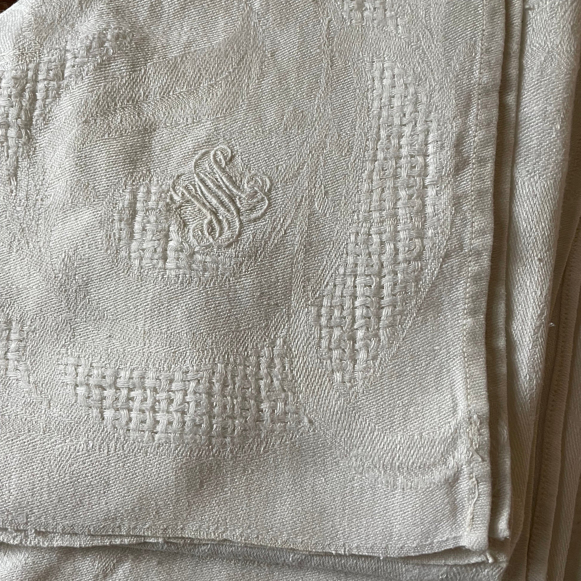 Close-up of a textured fabric with an embroidered design on a wooden surface
