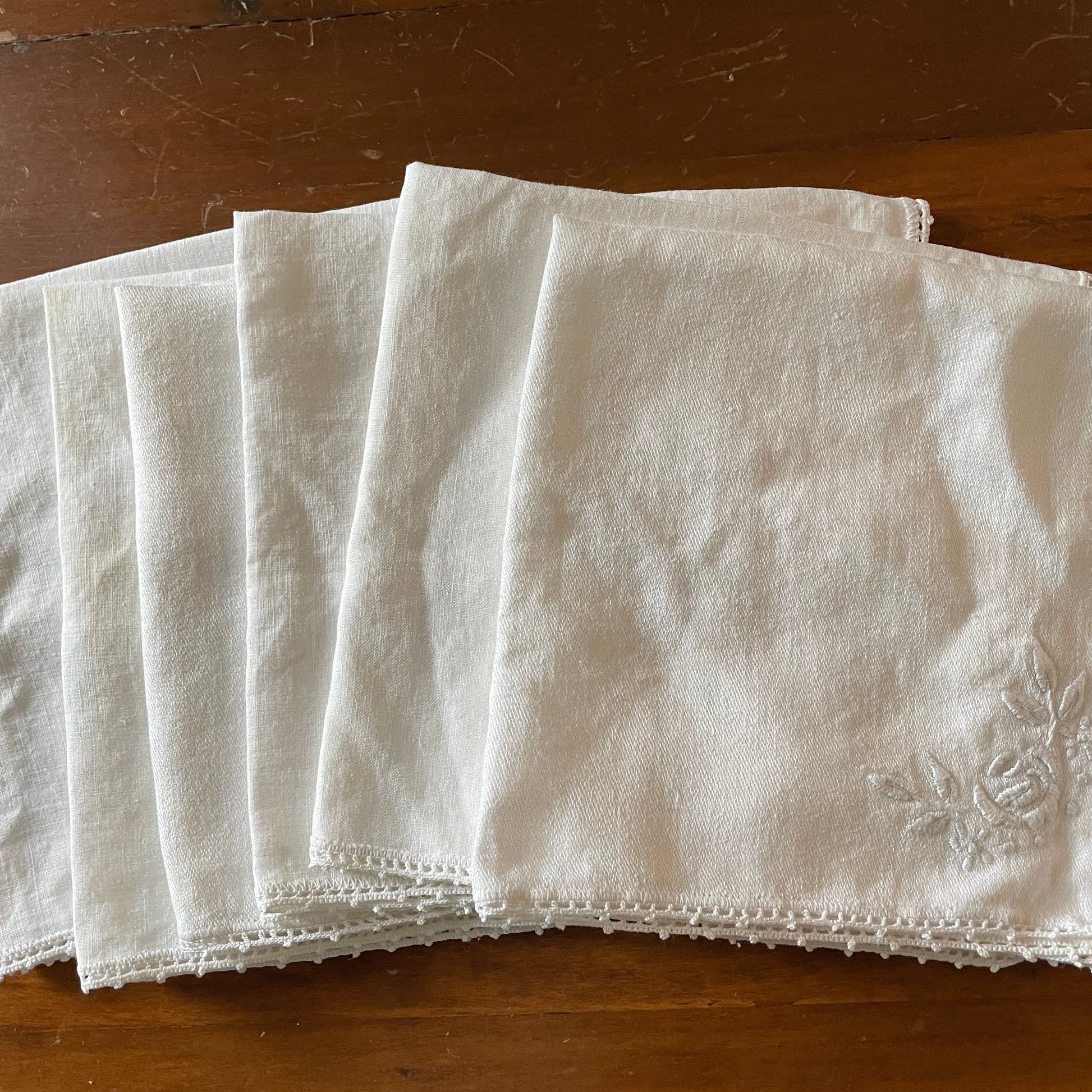 Stack of white fabric napkins on a wooden surface