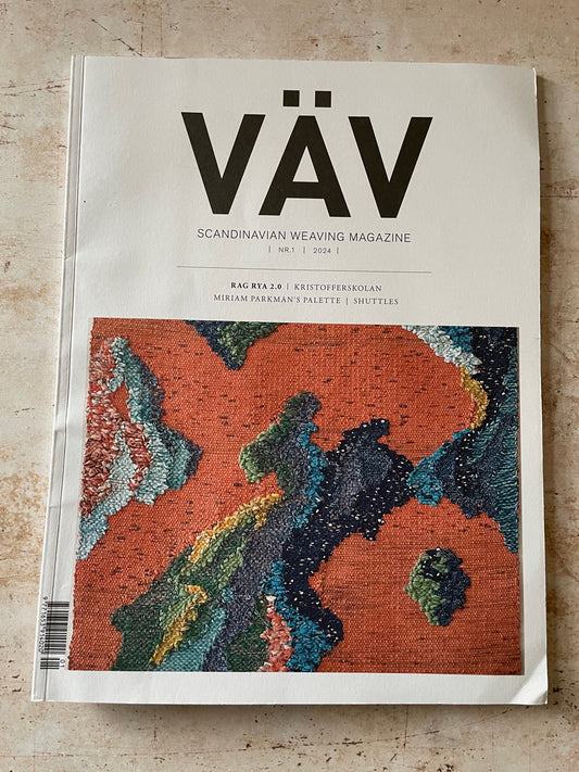 A physical copy of VÄV Scandinavian Weaving Magazine, issue 1/2024, featuring a prominent abstract woven textile cover design in terracotta orange, teal, and navy, displayed flat on a light beige stone surface.