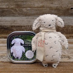 Stuffed sheep toy next to a tin labeled 'Live Sheep' on a wooden surface