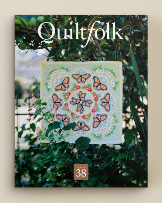 Quiltfolk magazine cover with a butterfly-themed quilt and greenery