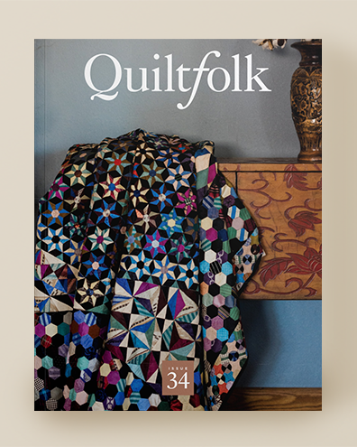 Magazine cover with a colorful quilt and 'Quiltfolk' branding on a beige background