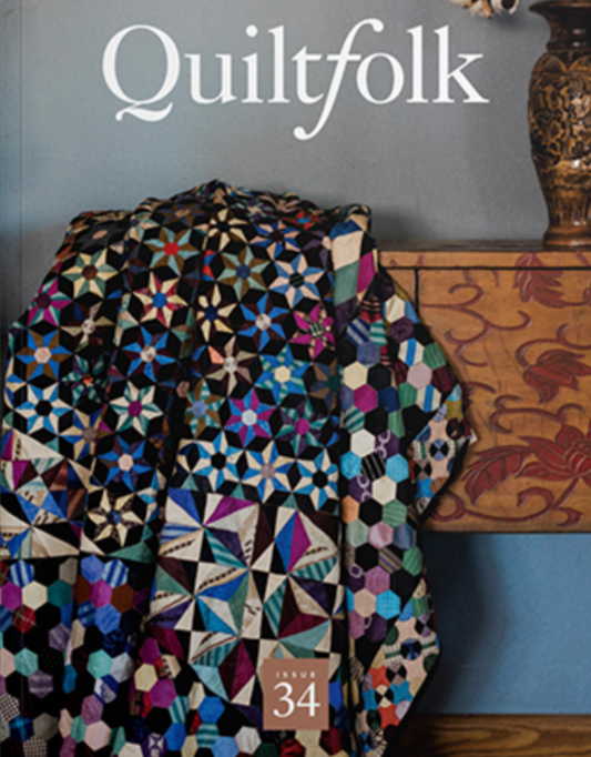 A colorful pinwheel quilt on a black base