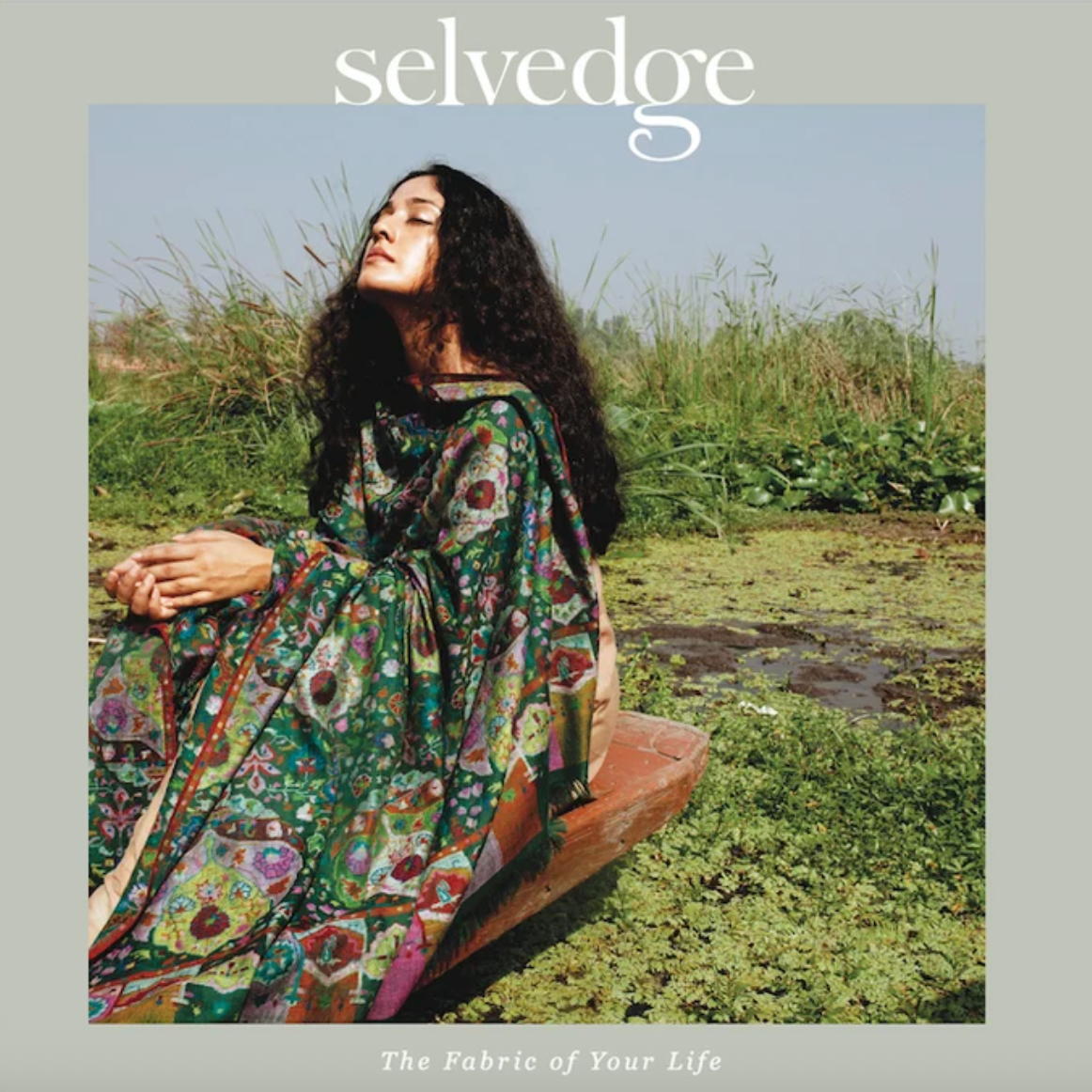 a magazine cover with a women sitting in a wooden boat wearing a green floral robe