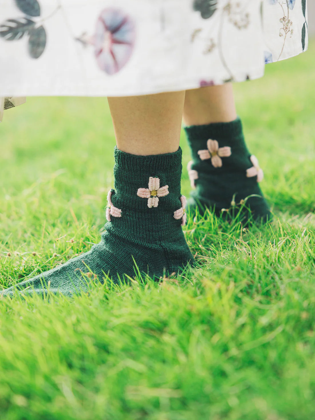 a pair of green socks with inks flowers