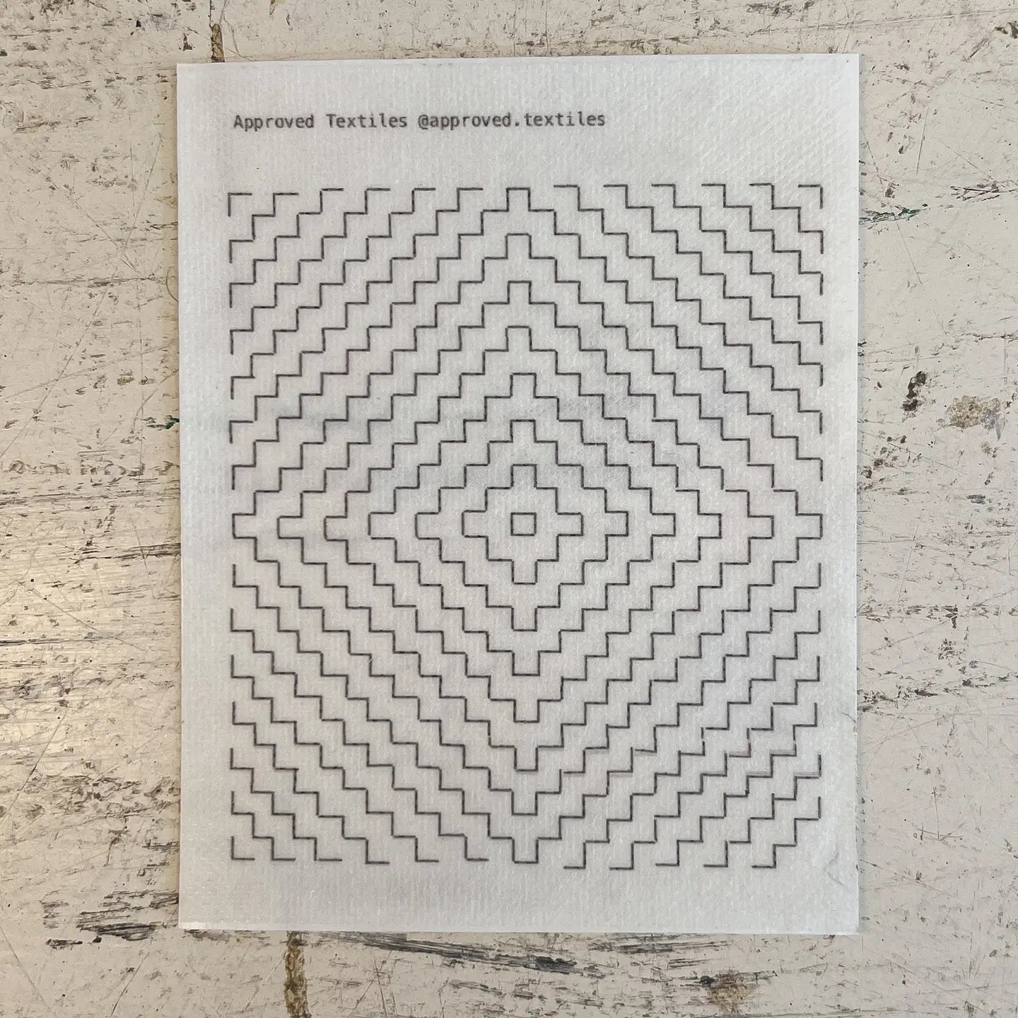 Textile sample with geometric pattern on a textured surface