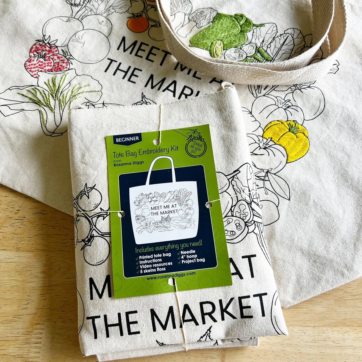 Tote bag embroidery kit with 'Meet Me at the Market' design on a wooden surface