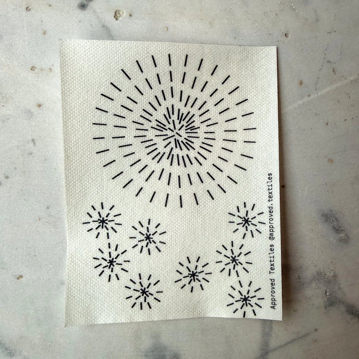 Textile with black geometric patterns on a marble surface