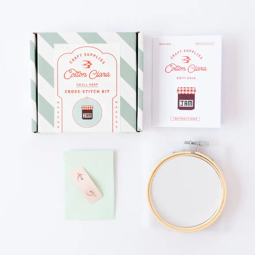 Cotton Clara cross-stitch kit with a hoop and other supplies on a white background