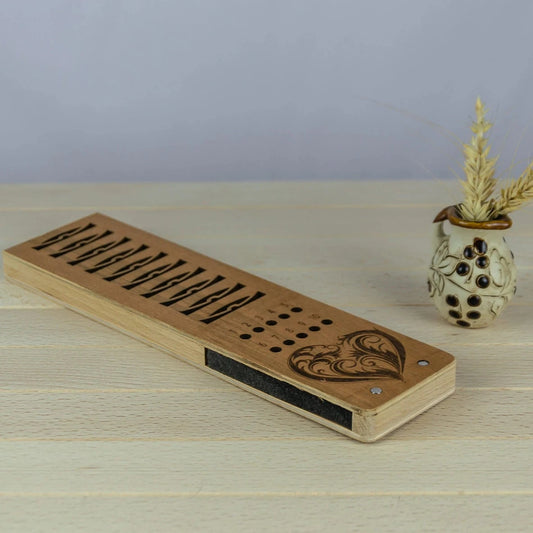 Wooden bobbin holder with decorative elements on a wooden surface