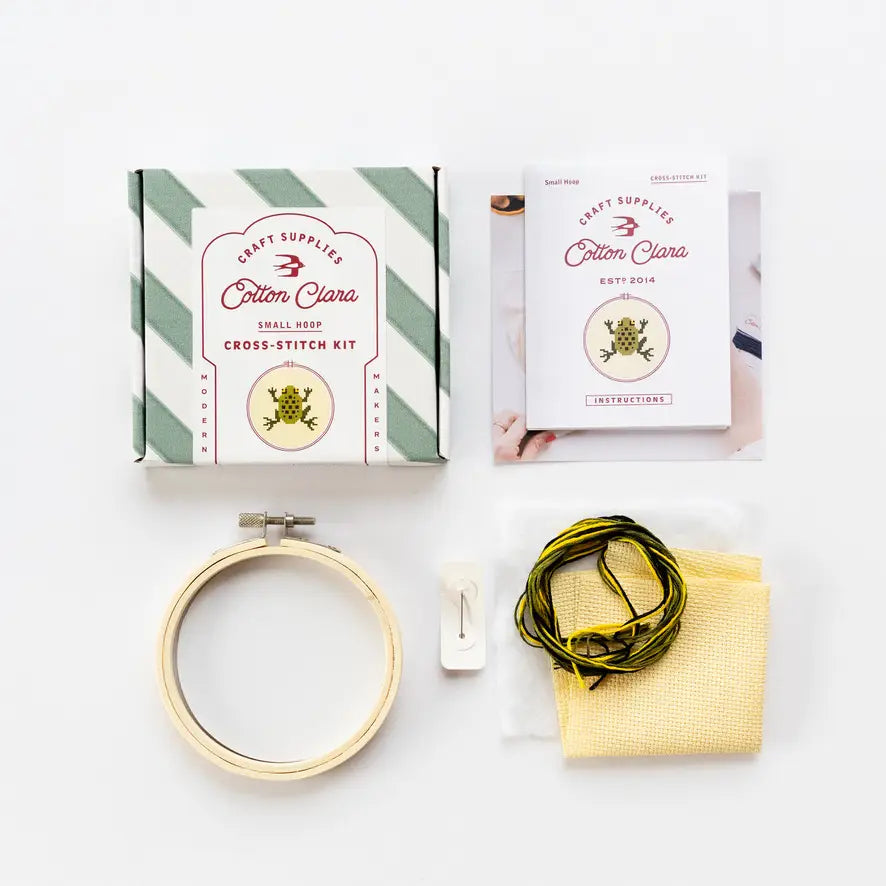 Cross-stitch kit with hoop, thread, and instructions on a white background