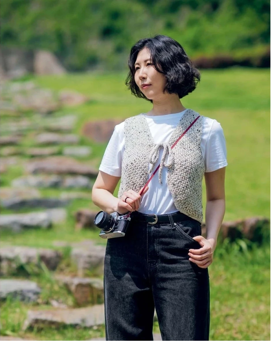 Person holding a camera in a scenic outdoor setting 
