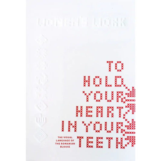 a white book cover with red cross stitch letters