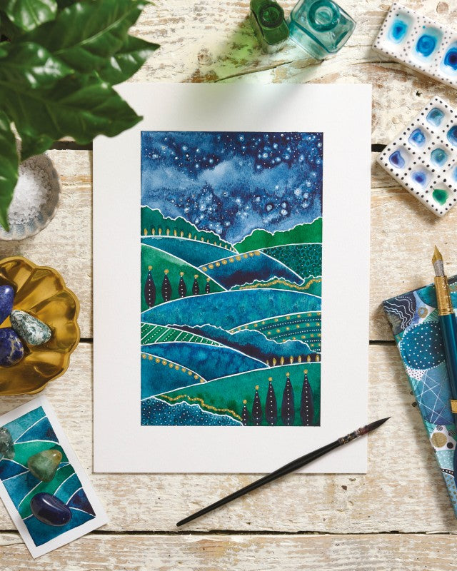 Artistic depiction of a landscape with a starry night sky on a wooden surface with art supplies.