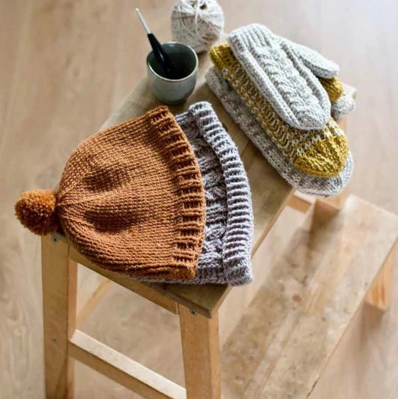 hats and mittens on a wood stool