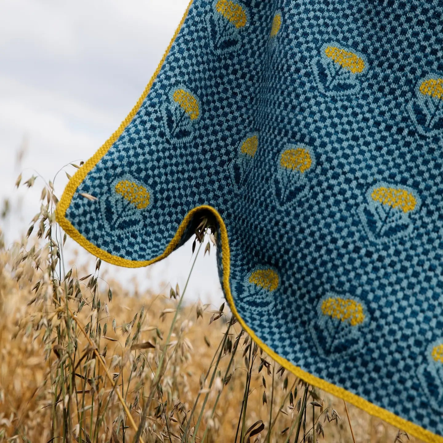 Yellow flowers on a blue checked knitted shawl