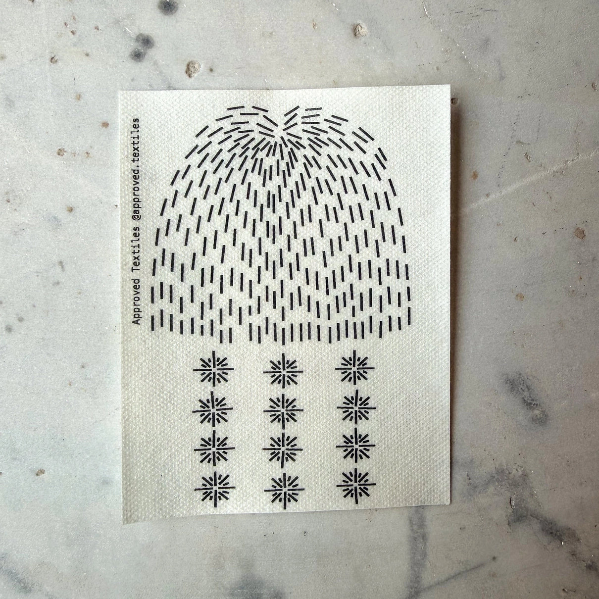 Sheet of black and white patterned stickers on a textured surface
