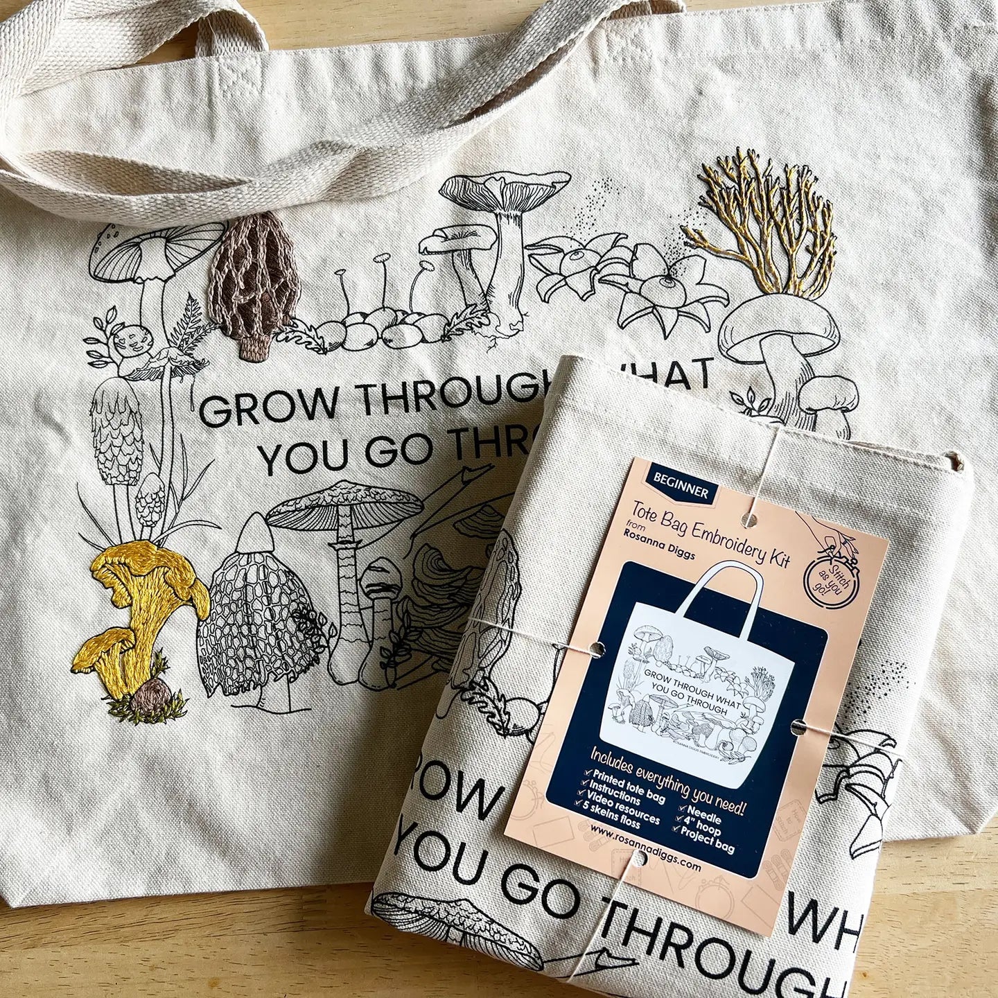 Embroidery kit with mushroom-themed tote bag on a wooden surface