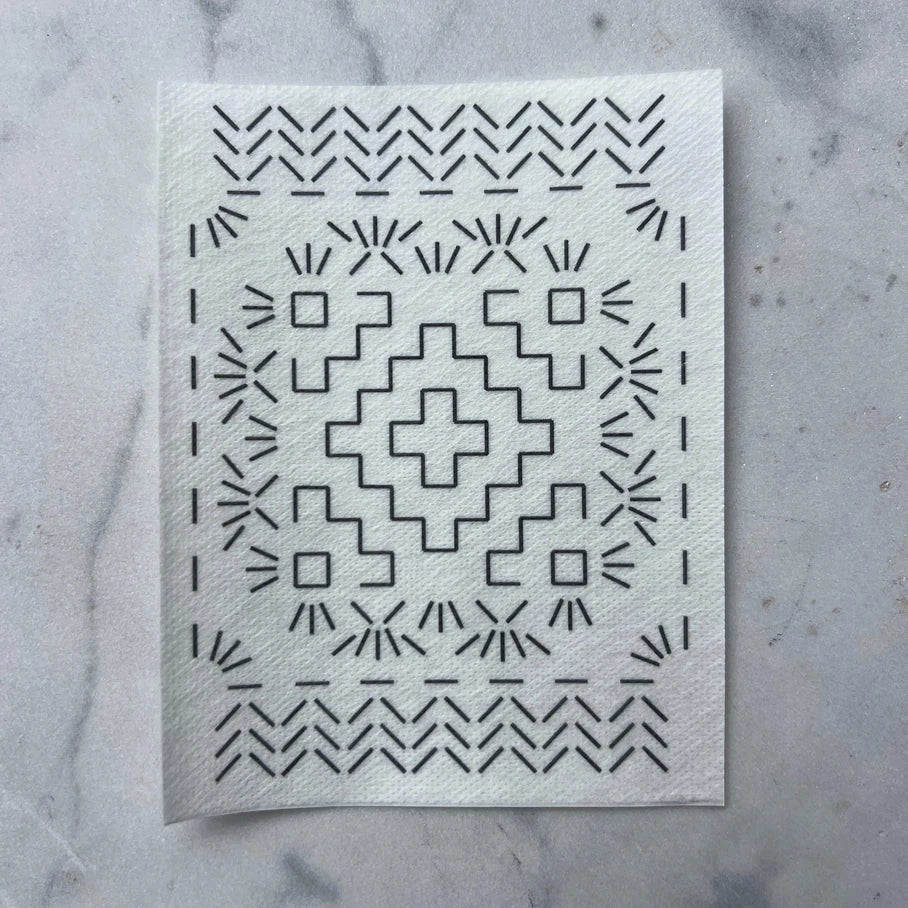White mending transfer with black geometric pattern on a marble surface