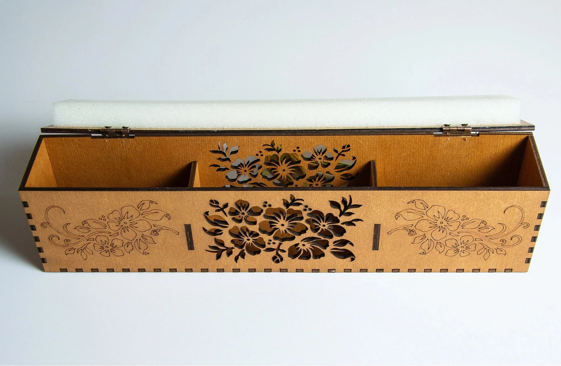 Wooden box with floral carvings on a white background