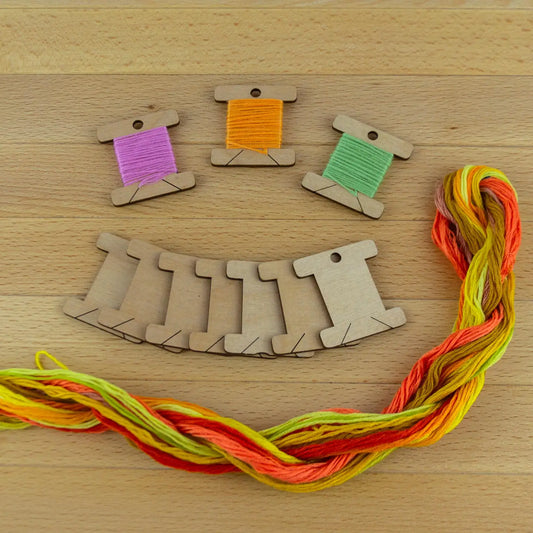 10 wooden thread bobbins on a wooden surface
