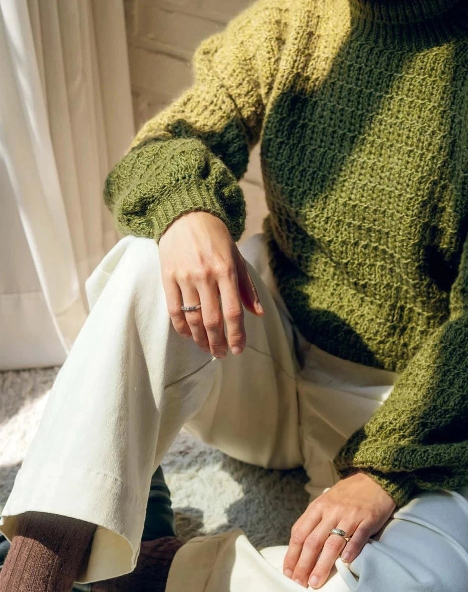 Person wearing a green knitted sweater 
