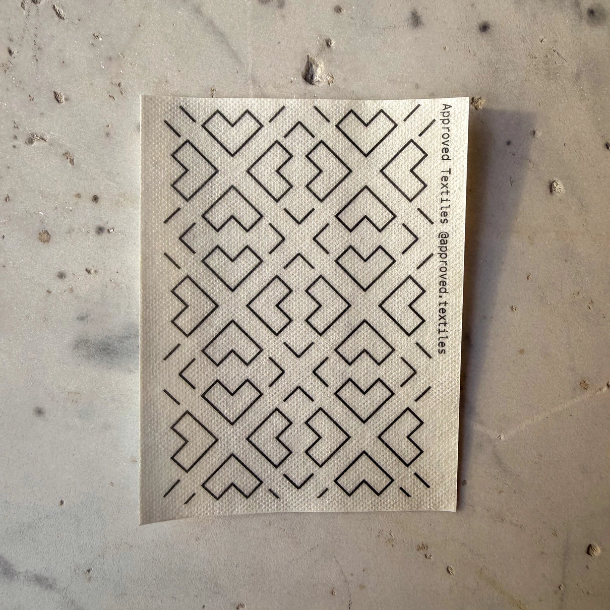 Textile sample with geometric pattern on a textured surface