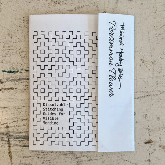 Booklet with geometric patterns and text on a textured surface